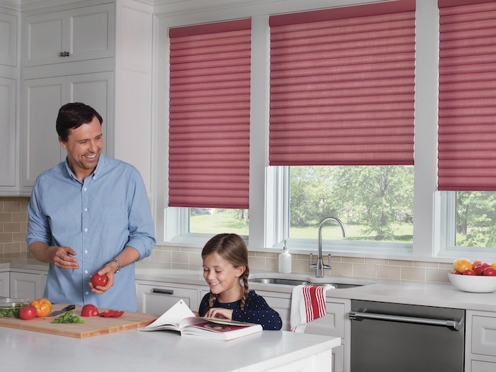 A kitchen with a father and daughter cooking together.